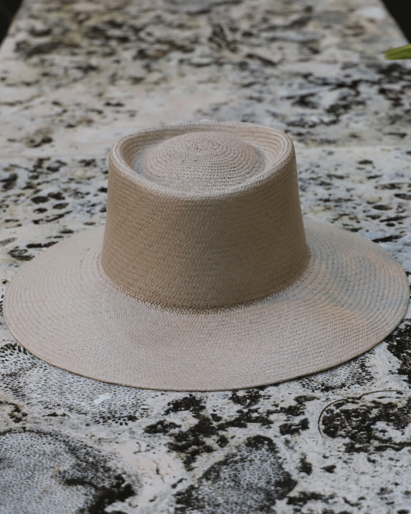 Ivory panama toquilla straw hat with an asymmetric crown and detachable silk ribbon.