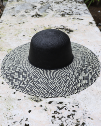 Black rounded crown panama toquilla straw hat with black and white patterned wide brim