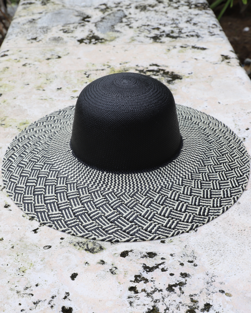 Black rounded crown panama toquilla straw hat with black and white patterned wide brim