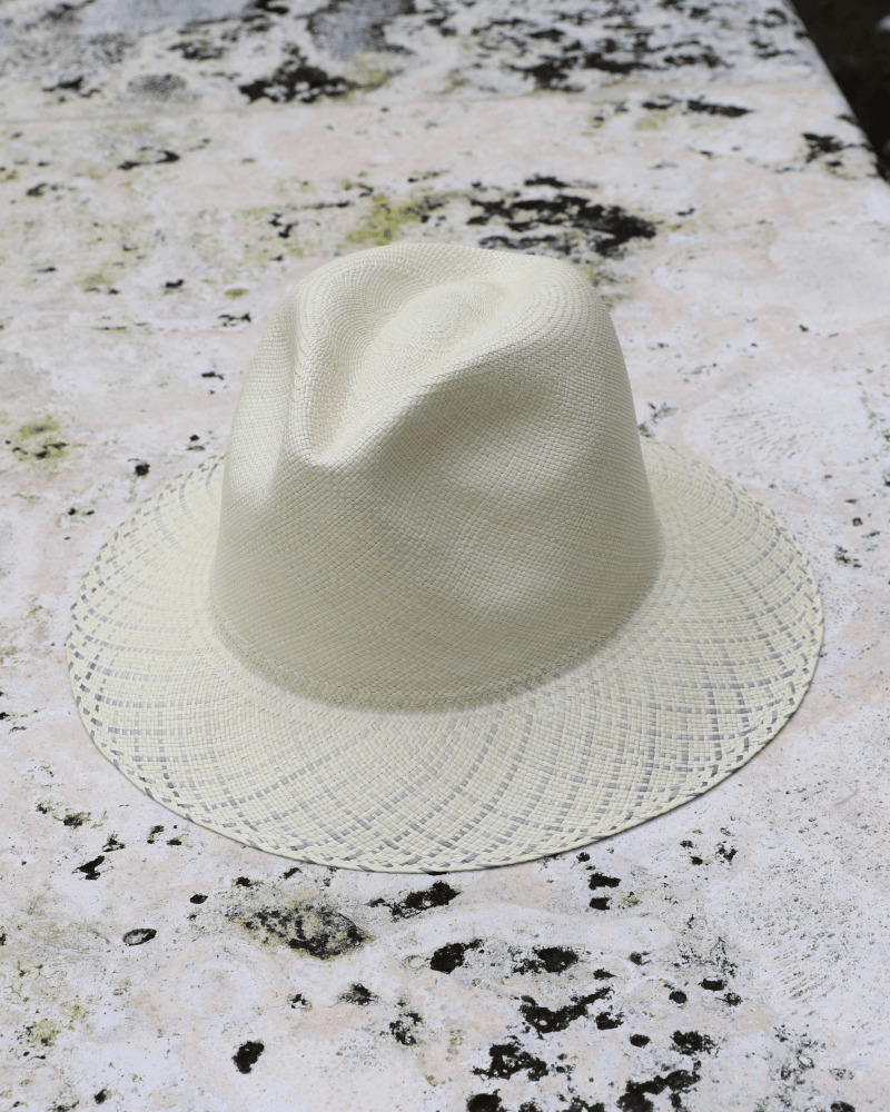 Ivory panama toquilla straw hat with pinched crown and blue-patterned brim